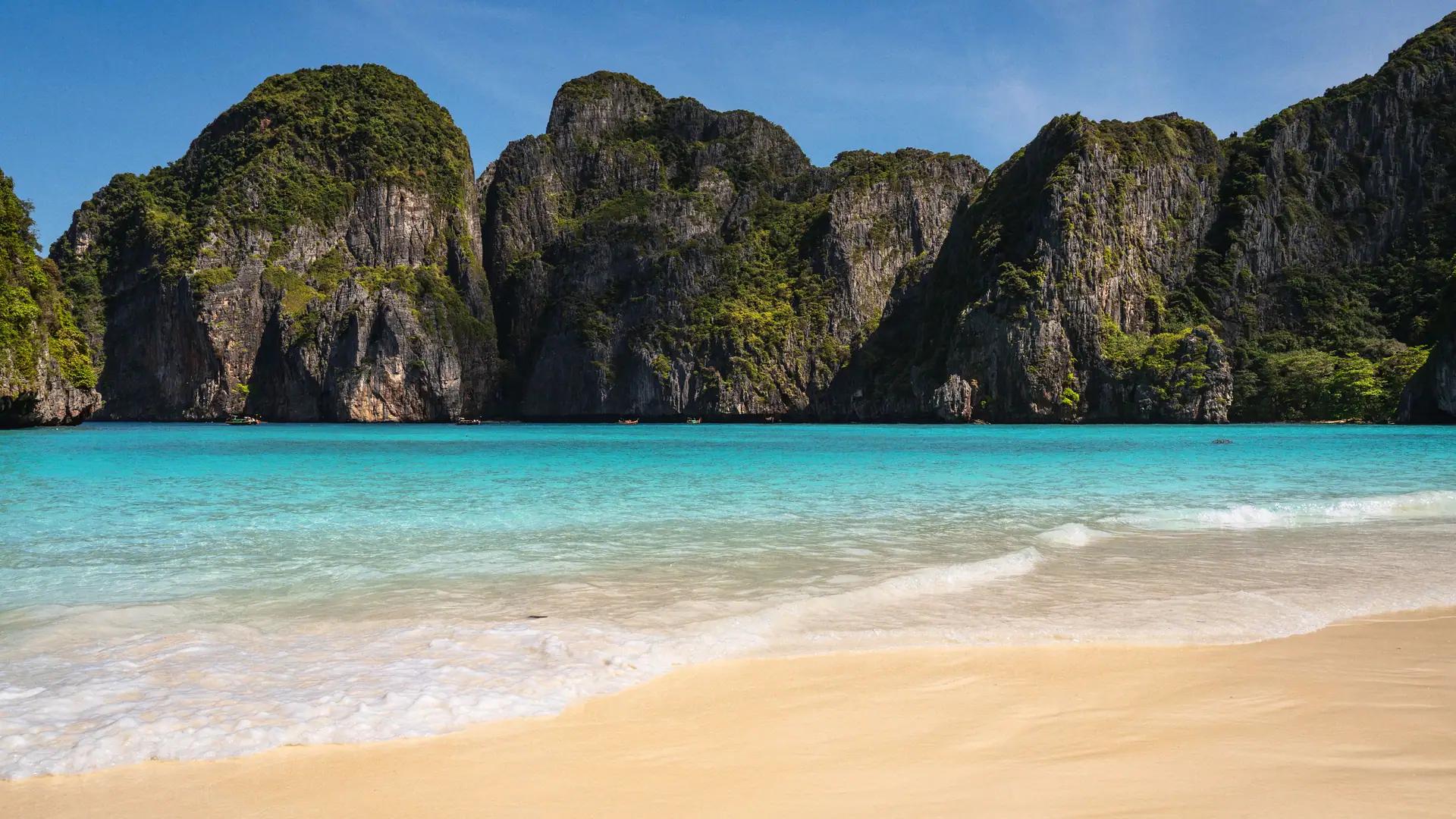 A property consultant greeting a buyer on a sea-view villa terrace in Thailand