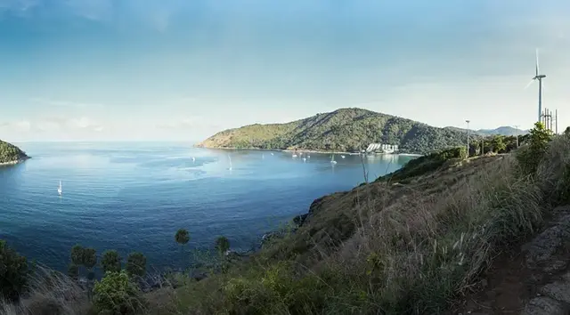 Nai Harn beach seen across its lagoon, with white sand between green headlands