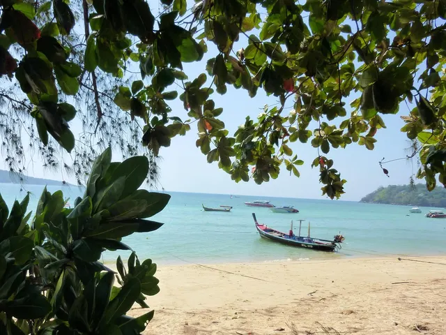 Longtail boats moored in shallow water off Rawai with islands on the horizon