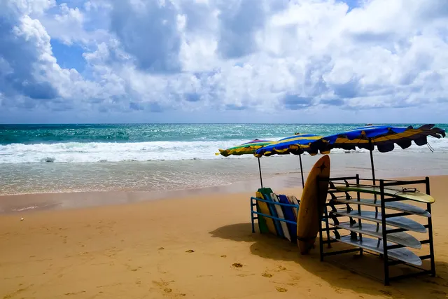 Surin beach with bright sand and swimmers framed by headland greenery